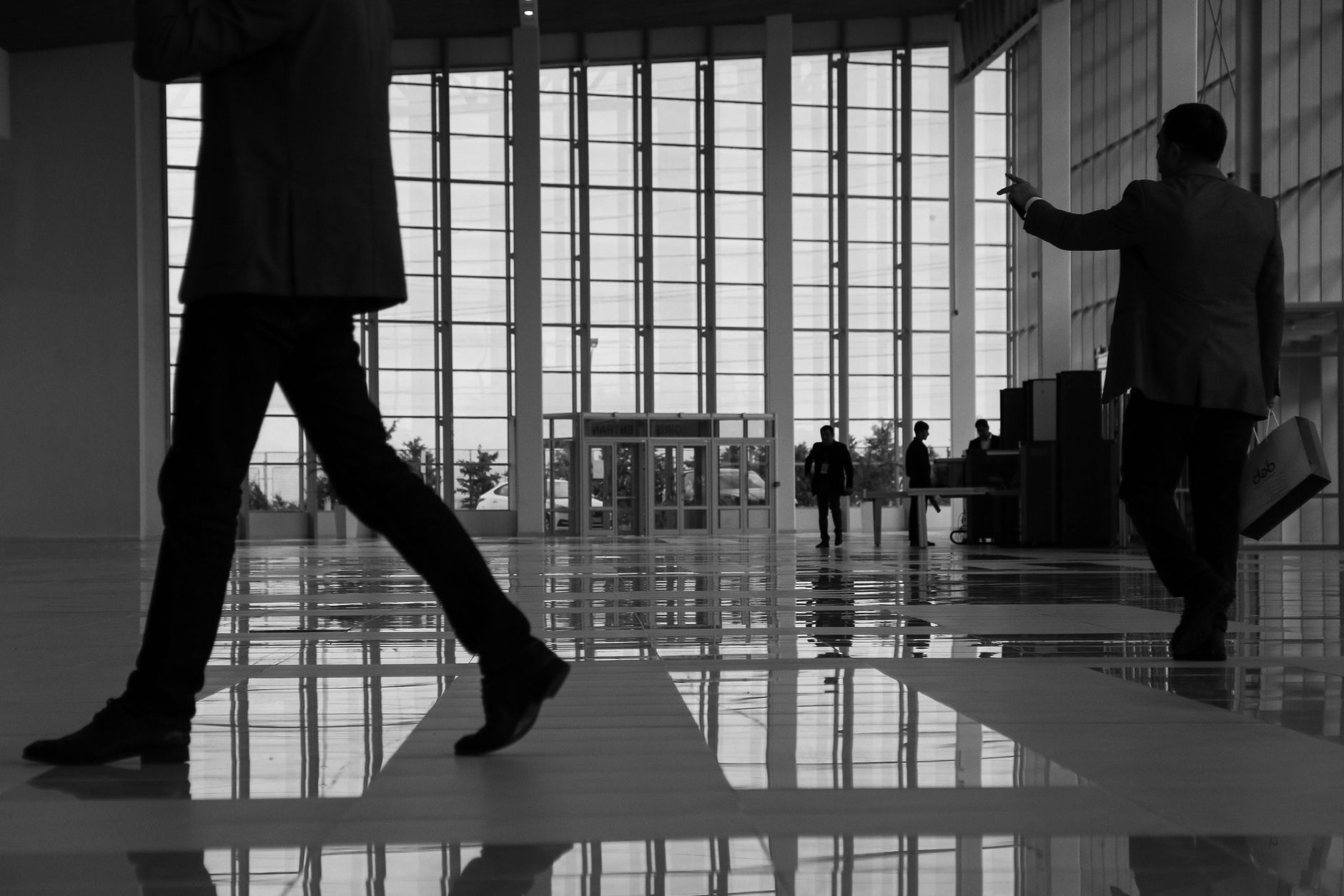 Business professionals walk through a modern, glass-paneled indoor space. — Diving into Demat Accounts: Unlocking the Gateway