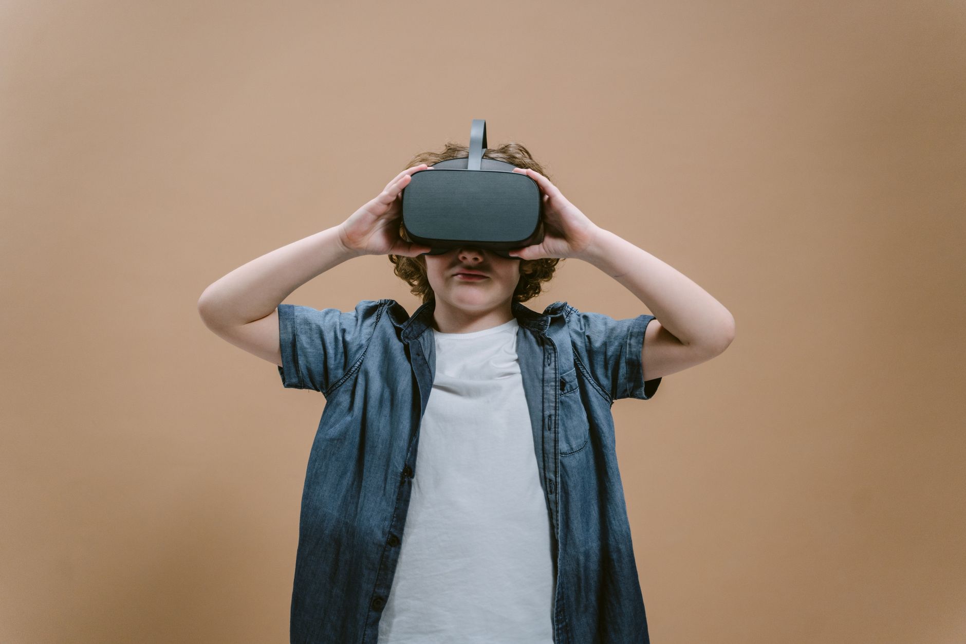 Child in studio using VR headset, engaging with modern technology on a plain background. — Drilling - Advanced Technology For