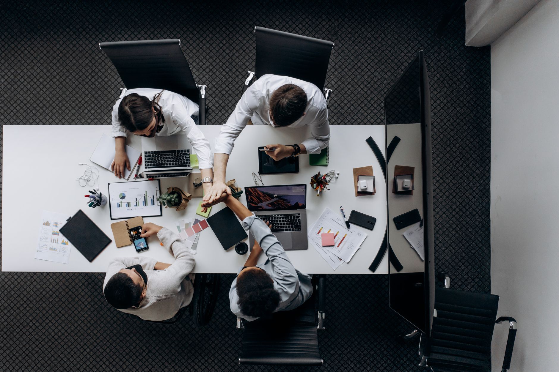 High angle view of colleagues collaborating around a conference table in a modern office setting. — Famoid- 5 Extremely Usefu