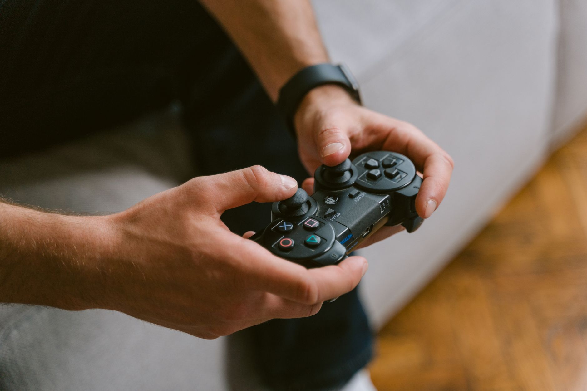 Hands holding a game controller while playing video games indoors, a leisure activity. — How to Choose an Online Betting Site