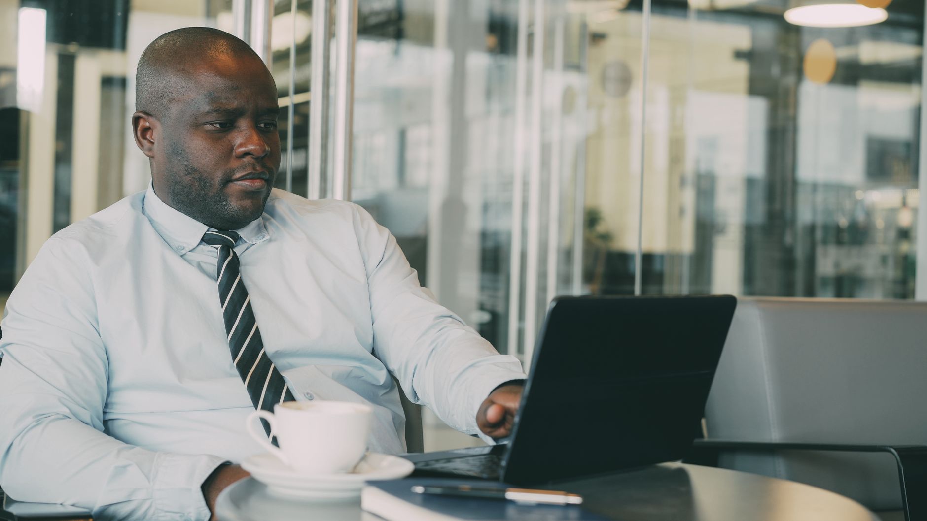 Focused businessman uses laptop in stylish cafe, sipping coffee. Perfect for business or lifestyle themes. — Pros of High Pay
