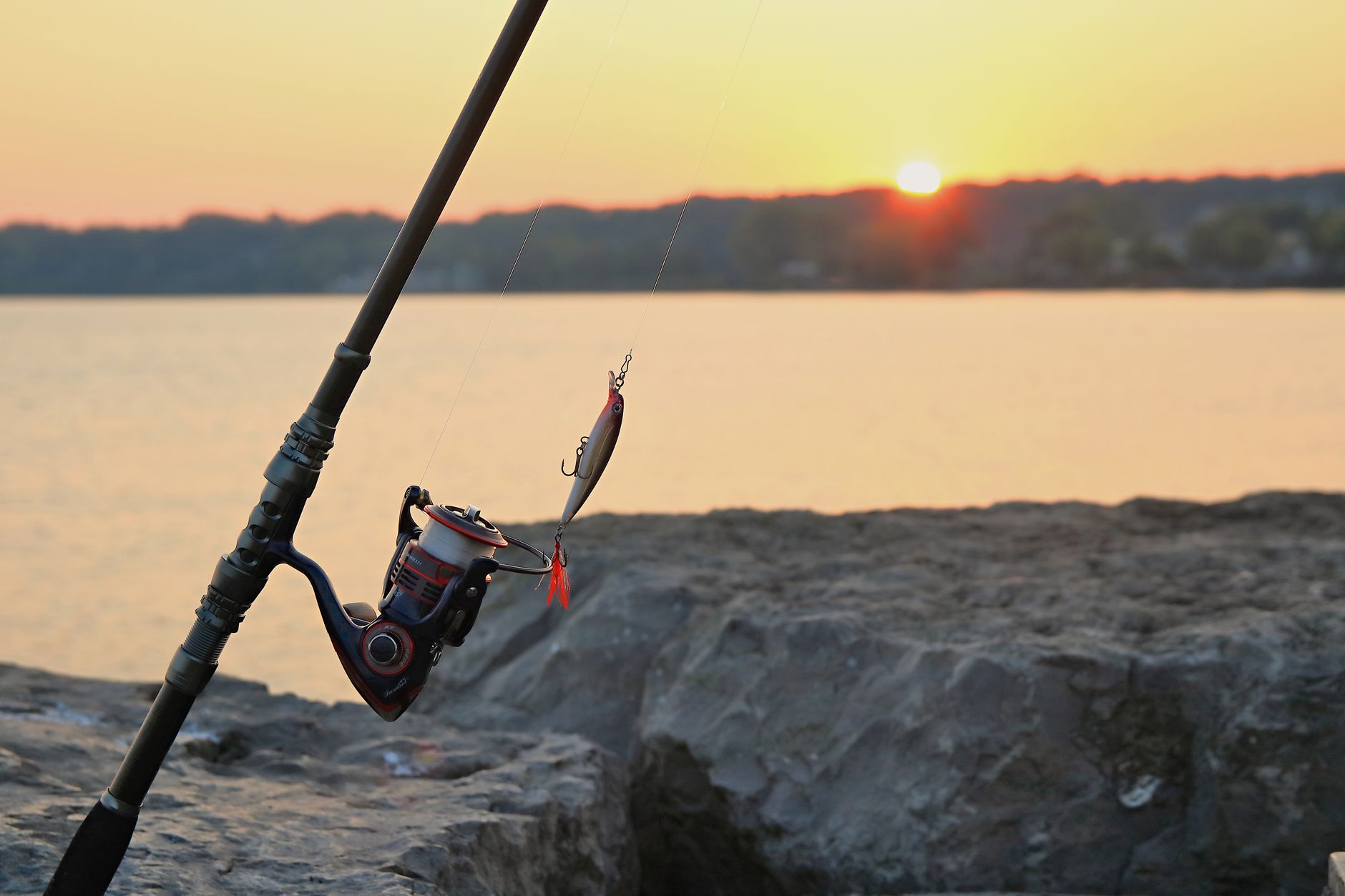 Fishing rod and lure at sunrise on a rocky pier in Webster Lake, NY. — Reasons Why You Need A Medicare Advantage Plan