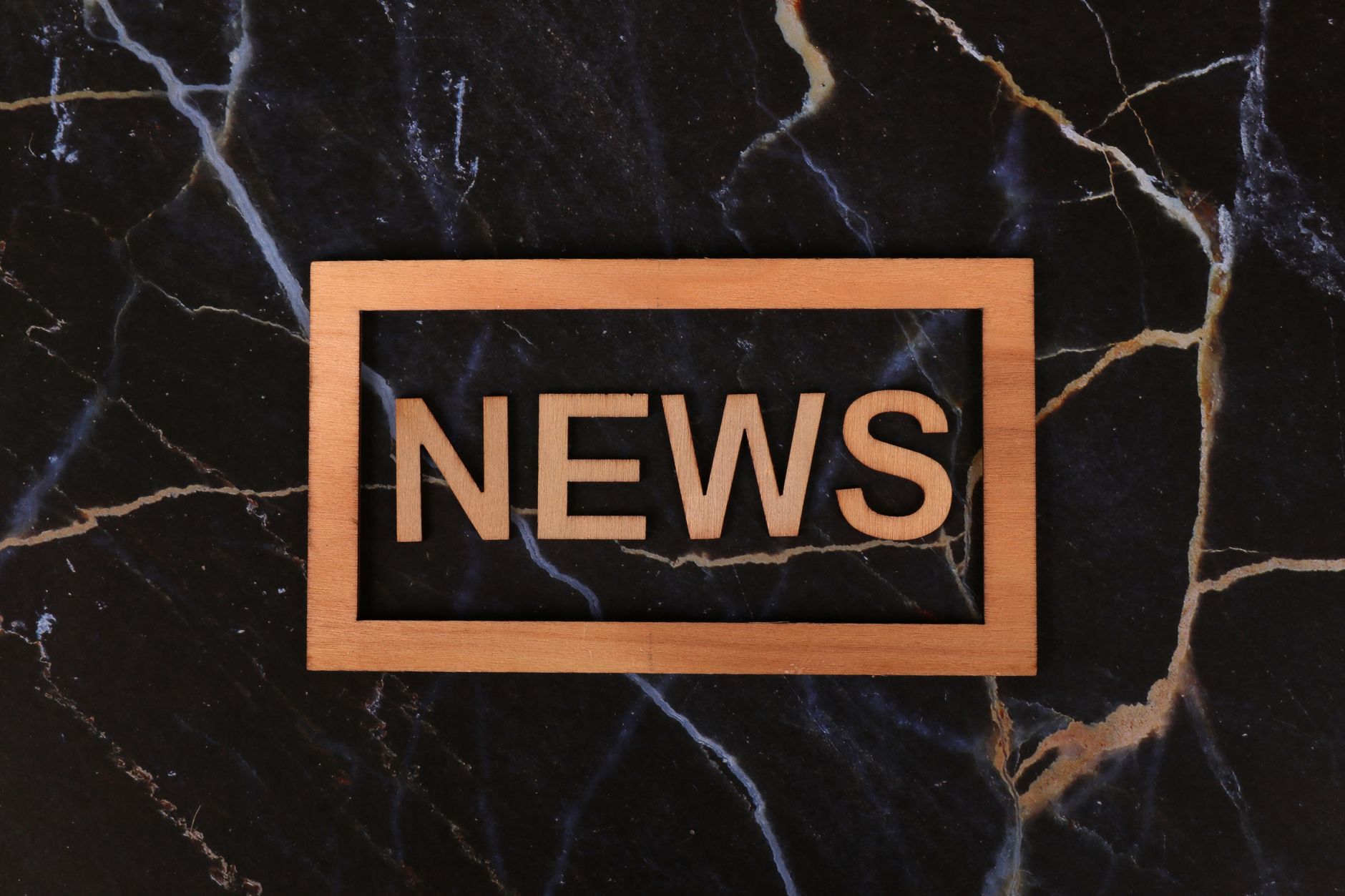 Wooden text of 'news' outlined on a dark, marbled surface, creating a striking contrast. — Improve Circulation With D