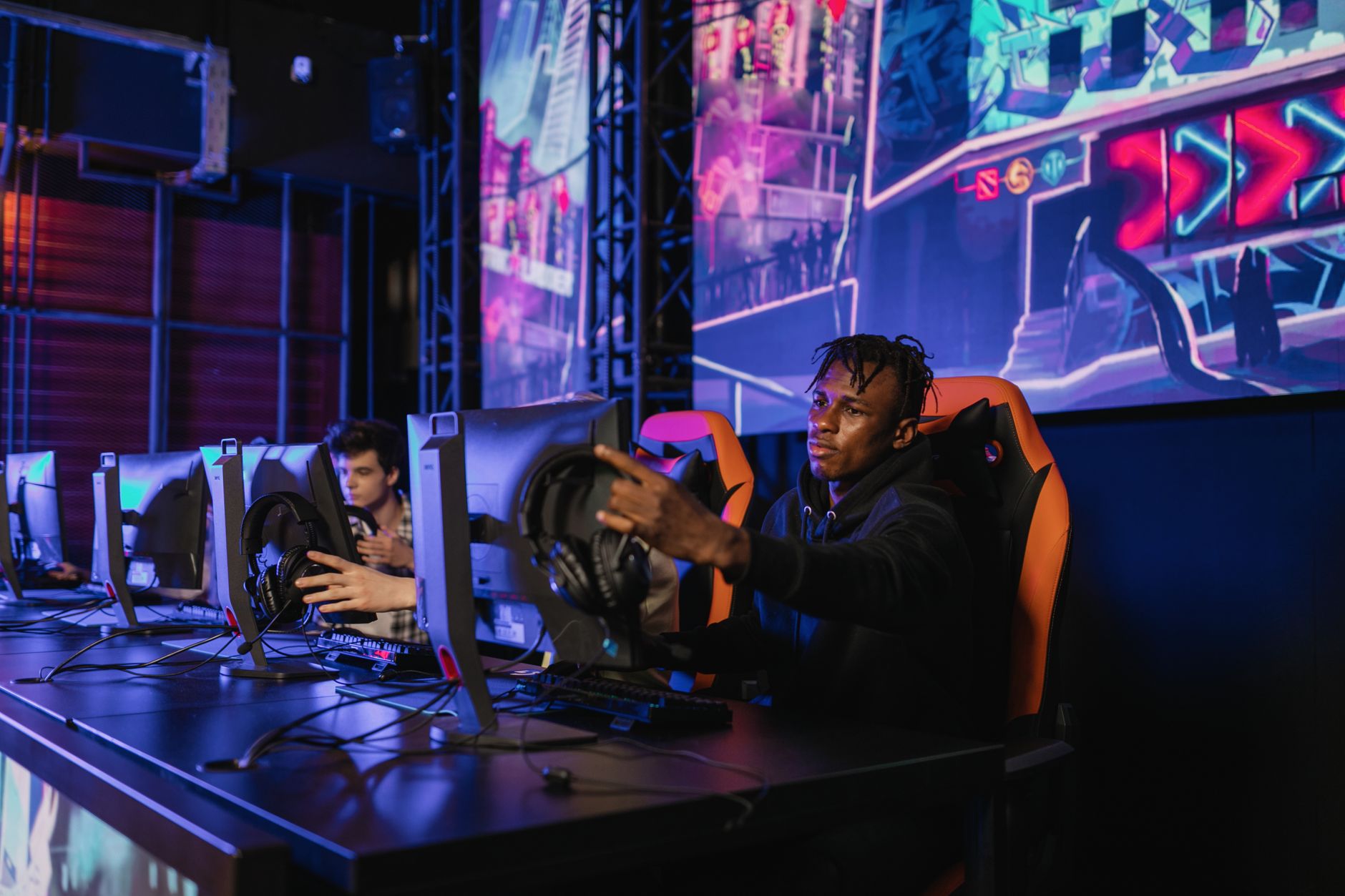Two gamers intensely focused in a professional eSports competition with vibrant game visuals. — The untold Advantages Within