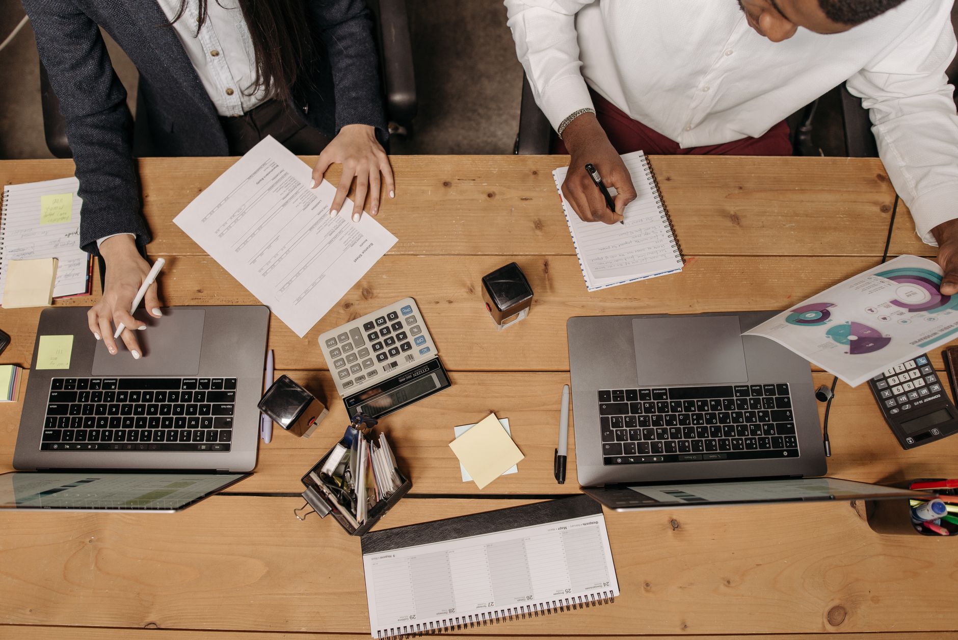 High-angle view of professionals working collaboratively with laptops and documents in an office. — Troubleshooting Your AD P