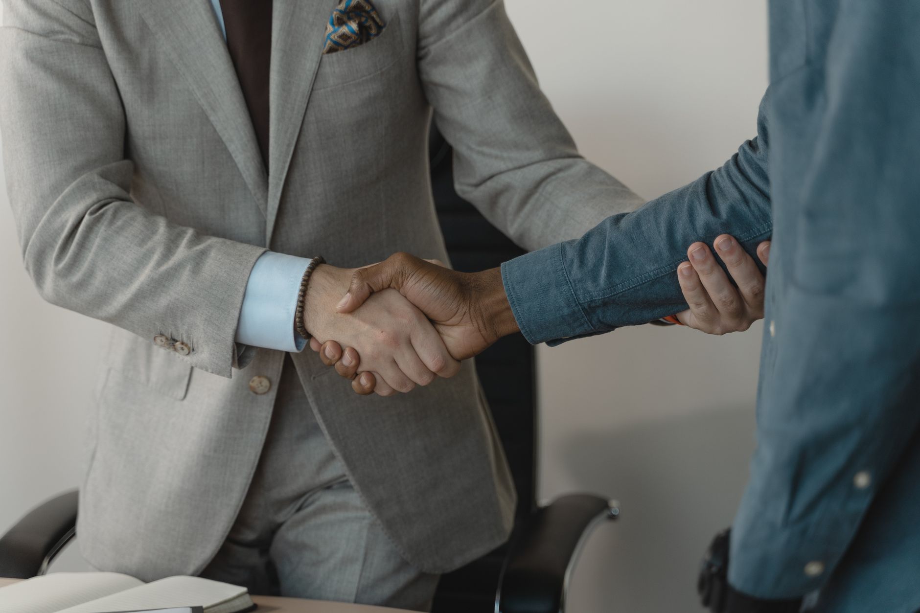 Image of a professional handshake between two businessmen in an office setting. — What Questions Should I Ask During a Yes or