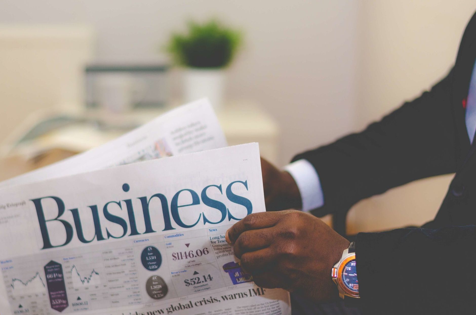 Close-up of a businessman reading a newspaper indoors, focusing on business headlines. — Why Is Gate Installation Important?
